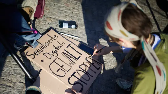 Ein Transparent mit der Aufschrift Sexualisierte + Digitale Gwalt stoppen wird für Demonstration gegen sexualisierte digitale Gewalt auf dem Pariser Platz vorbereitet.