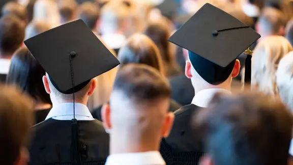 Absolventen tragen bei einer Abschlussfeier ihrer Universität einen Absolventenhut.