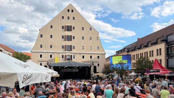 Menschen sitzen in Zittau auf Bänken.