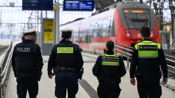 Bundespolizisten und zwei Sicherheitsmitarbeiter der Bahn gehen am Hauptbahnhof Dresden auf einem Bahnsteig entlang.