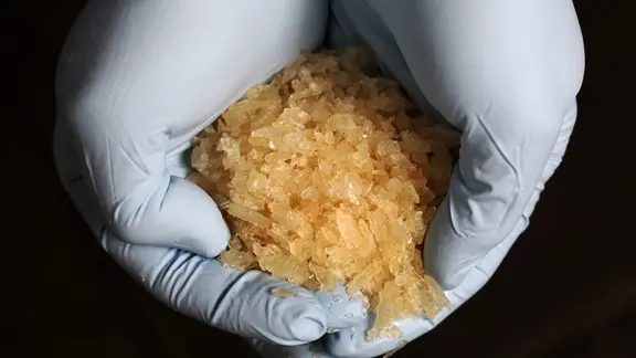 Ein Ermittler hält die Droge Crystal in seinen Händen