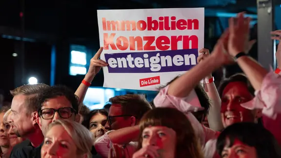 Auf einer Wahlparty der Linken nach der Abgeordnetenhauswahl in Berlin hält eine Person ein Plakat mit der Aufschrift "Immobilien Konzern enteignen" hoch