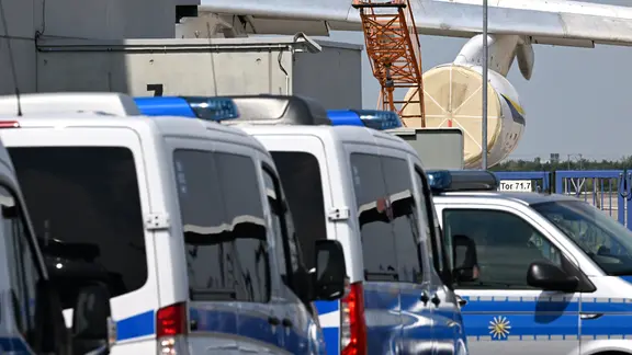 Einsatzfahrzeuge der Polizei stehen in der Nähe eines ukrainischen Flugzeugs auf dem Flughafen Leipzig/Halle. Die sächsische Polizei hat die Ermittlungen zum nächtlichen Drohnen-Vorfall am Flughafen Leipzig/Halle übernommen.