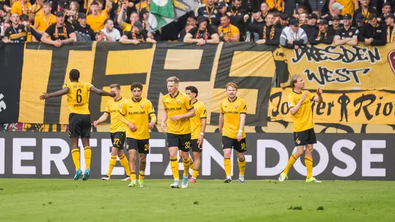 Fussballer und Fans jubeln. 