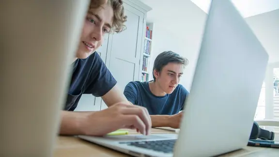Zwei Teenager arbeiten an Laptop und Tablet