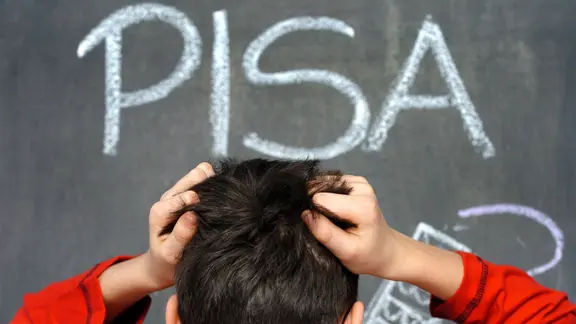Der Schüler Arne rauft sich in Schwerin vor dem mit Kreide an eine Schultafel geschriebenen Wort «PISA» die Haare. 