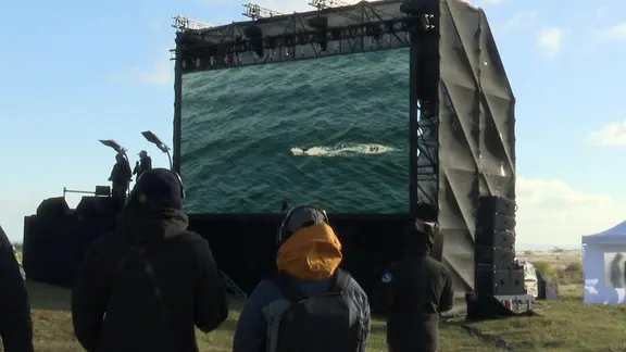 Zuschauer sehen ein Video auf einer großen Leinwand