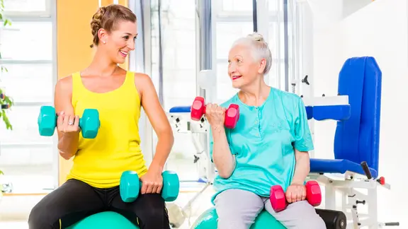 Jüngere und ältere Frau beim Krafttraining mit Hanteln