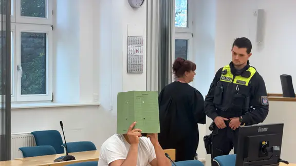 ein Mann mit einer akte vor dem Gesicht