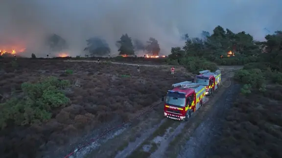 Englische Feuerwehrfahrzeuge vor einer Feuer-auch Rauchwand
