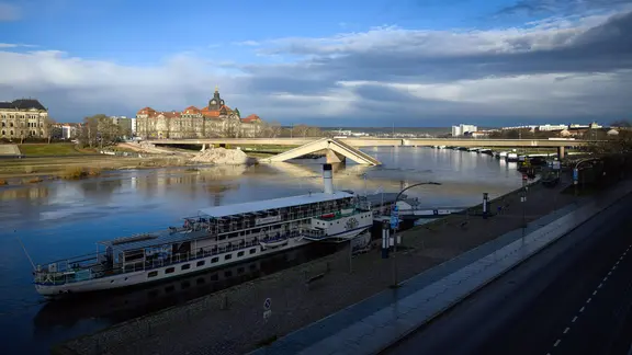 Blick über den Dampfer „Leipzig“ der Sächsischen Dampfschifffahrt auf die teileingestürzte Carolabrücke an der Elbe, im Hintergrund ist die Staatskanzlei zu sehen.