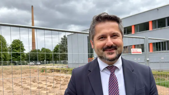 Landrat Michael Brodführer (CDU) steht vor einer Baustelle am Eisenacher Berufsschulzentrum
