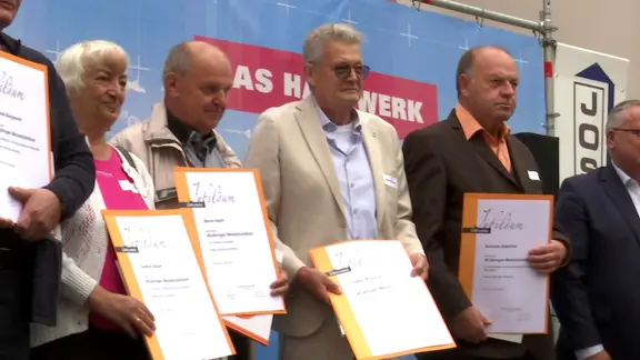Handwerksmeister mit Urkunden