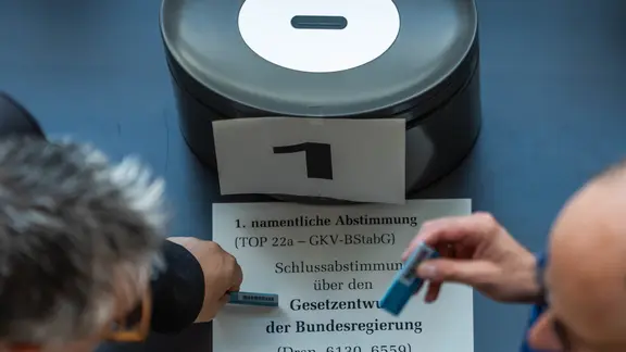 Abgeordnete stehen an der Wahlurne im Bundestag.