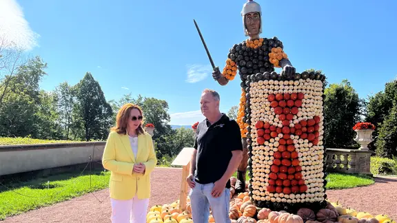 Zwei Menschen stehen vor einer Legionärsfigur aus Kürbissen.