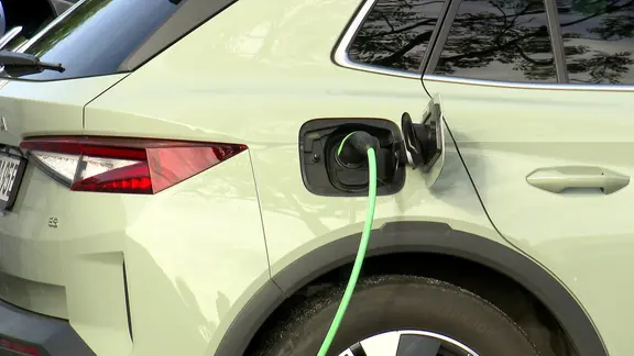 Seitlicher Blick auf die Heckpartie eines E-Autos mit eingestecktem Ladekabel