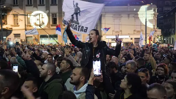 Demonstranten mit Fahnen und leuchtenden Handys auf einem Studentenprotest in Belgrad