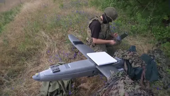 Ein ukrainischer Soldat installiert ein Starlink-Terminal auf einer Drohne. 