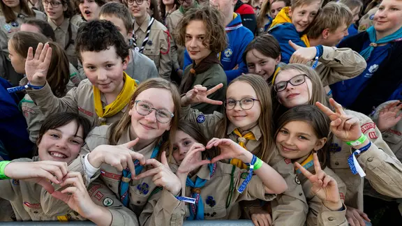 Eine Gruppe Jugendlicher in Uniform der Pfadfinder schaut fröhlich in die Kamera