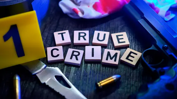 Schriftzug True Crime mit Waffe, Messer und blutigem Tuch