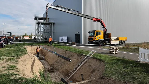 Bauleute verlegen ein Stück der Wasserstoff-Pipeline auf dem Gelände des BMW-Werks Leipzig. 