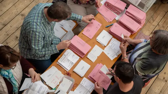 Wahlhelfer sortieren Briefwahlunterlagen.