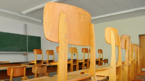 Ein leeres Klassenzimmern mit hochgestellten Stühlen