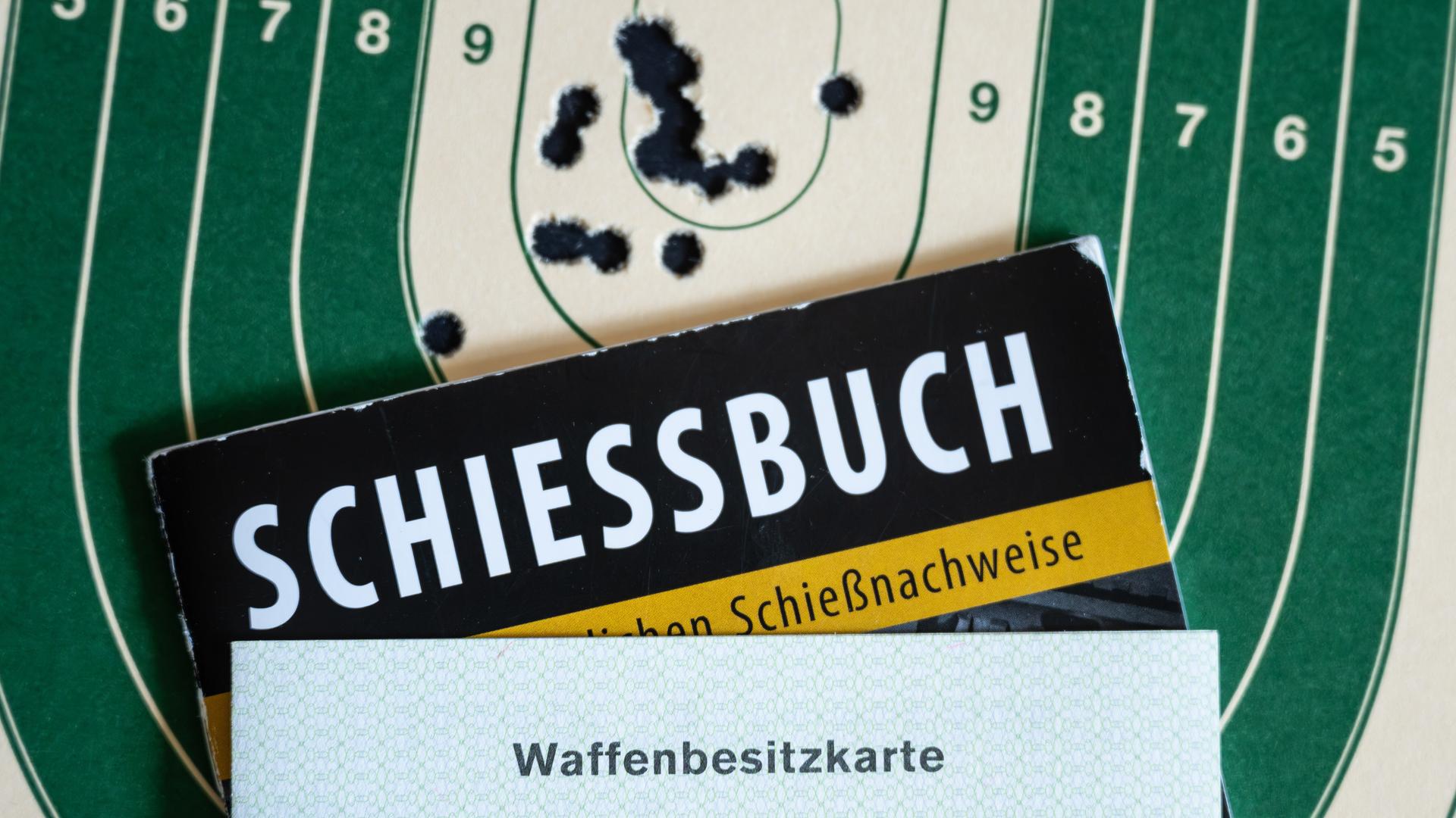 Schiessbuch und Waffenbesitzkarte liegen auf Zielscheibe | picture alliance/dpa | Silas Stein