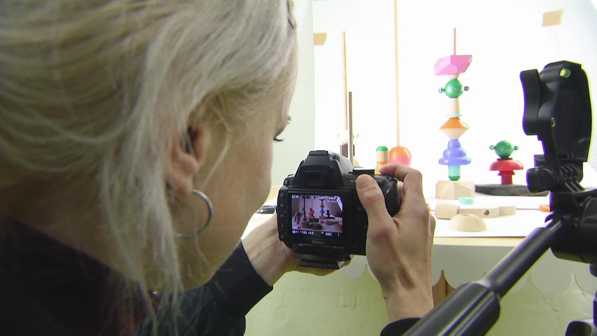 Eine Frau fotografiert ein gedrechseltes Spielzeug. | MITTELDEUTSCHER RUNDFUNK