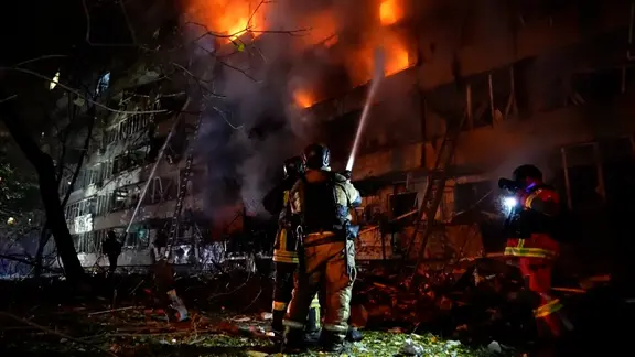 Feuerwehrleute löschen ein brennendes Haus nach einem russischen Luftangriff auf die ukrainische Hauptstadt Kiew.