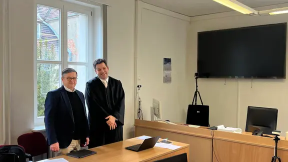 Der CDU-Landtagsabgeordnete Detlef Gürth (l) und sein Anwalt Philipp Gehrmann stehen im Gerichtsaal. Vor dem Amtsgericht Aschersleben muss sich Gürth erneut wegen des Vorwurfs der Volksverhetzung verantworten.
