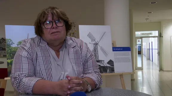 Christel Güldenpfennig sitzt an einem Tisch