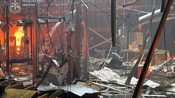 Trümmer und Feuer in einem Einkaufszentrum nach einem russischen Drohnenangriff. 