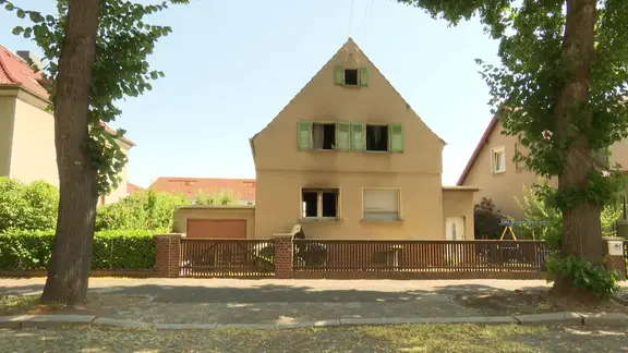 Ein Haus ist nach einem Brand verrußt.