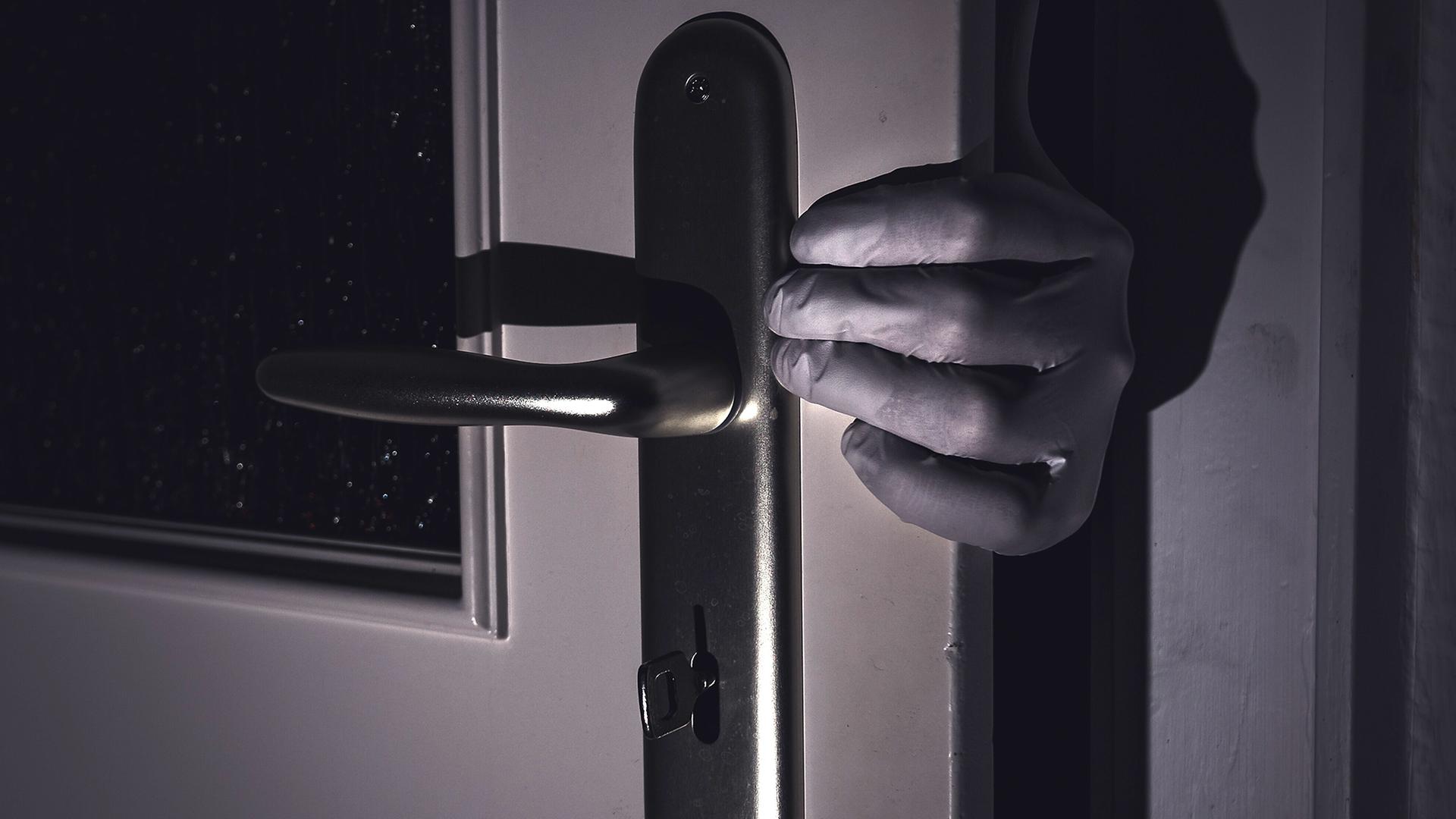 Eine behandschuhte Hand an einer Tür | picture alliance/dpa/Nicolas Armer