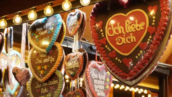 Lebkuchenherzen hängen an einem Stand.
