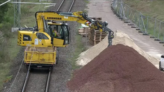 Ein Bagger auf einer Gleisbaustelle.