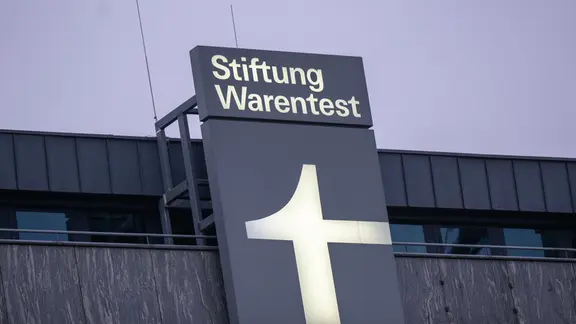 Ein Leuchtschild mit dem Logo der Stiftung Warentest ist an einem Geschäftshaus am Lützowplatz angebracht.