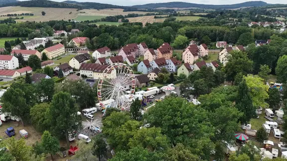 Ein Blick auf ein Riesenrad, dahinter Einfamilienhäuser