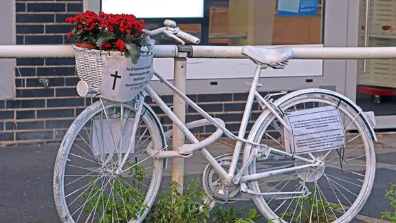 Am Rand einer stark befahrenen Straße, die als Unfallschwerpunkt gilt, befindet sich ein sogenanntes weißes Ghost-Bike nach einem tödlichen Unfall.