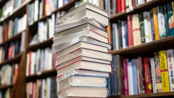 Μια στοίβα από νέα βιβλία βρίσκεται σε ένα τραπέζι πωλήσεων σε ένα βιβλιοπωλείο picture alliance/dpa | Φρανκ Ράμπενχορστ Μια στοίβα από νέα βιβλία βρίσκεται σε ένα τραπέζι πωλήσεων σε ένα βιβλιοπωλείο