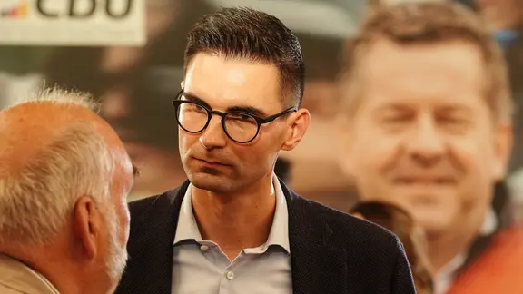 Mann mit kurzen dunklen Haaren und Brille