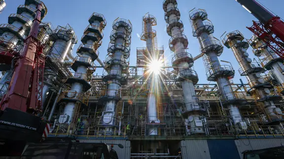 Die Sonne scheint hinter einer 26 Meter hohen Kolonne zur Phenolherstellung bei der Domo Chemicals GmbH. 