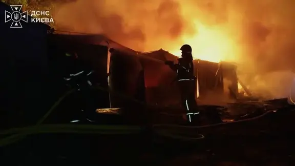 Brennendes Gebäude und ein Feuerwehrmann