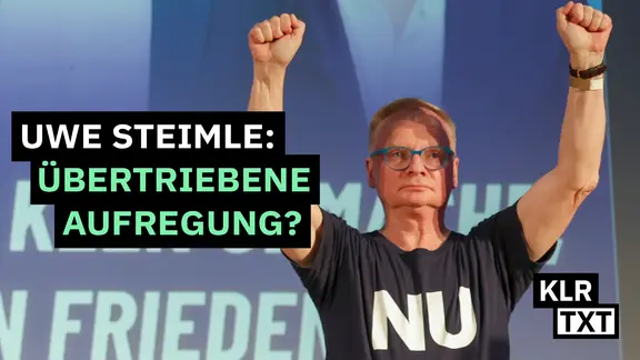 Uwe Steimle steht auf einer Bühne und reckt die Fäuste nach oben.