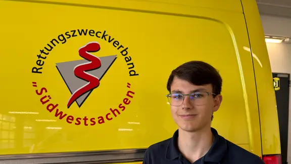 Lukas Neubert vor einem Rettungswagen.