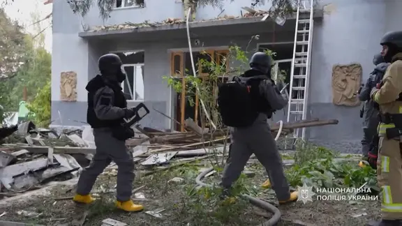 Ukrainische Rettungskräfte vor einem zerstörten Universitätsgebäude in Riwne.