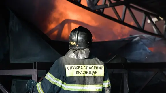 Russischer Feuerwehrmann steht vor einem Warenhaus, in dem ein Feuer ausgebrochen ist. (Russland, Lenina in der Region Krasnodar)