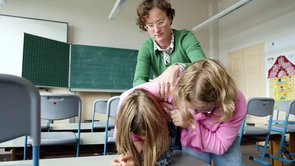 Einen Lehrerin trennt zwei streitende Schülerinnen