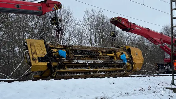 Eine verunglückte Gleisbaumaschine wird von zwei Eisenbahndrehkränen geborgen